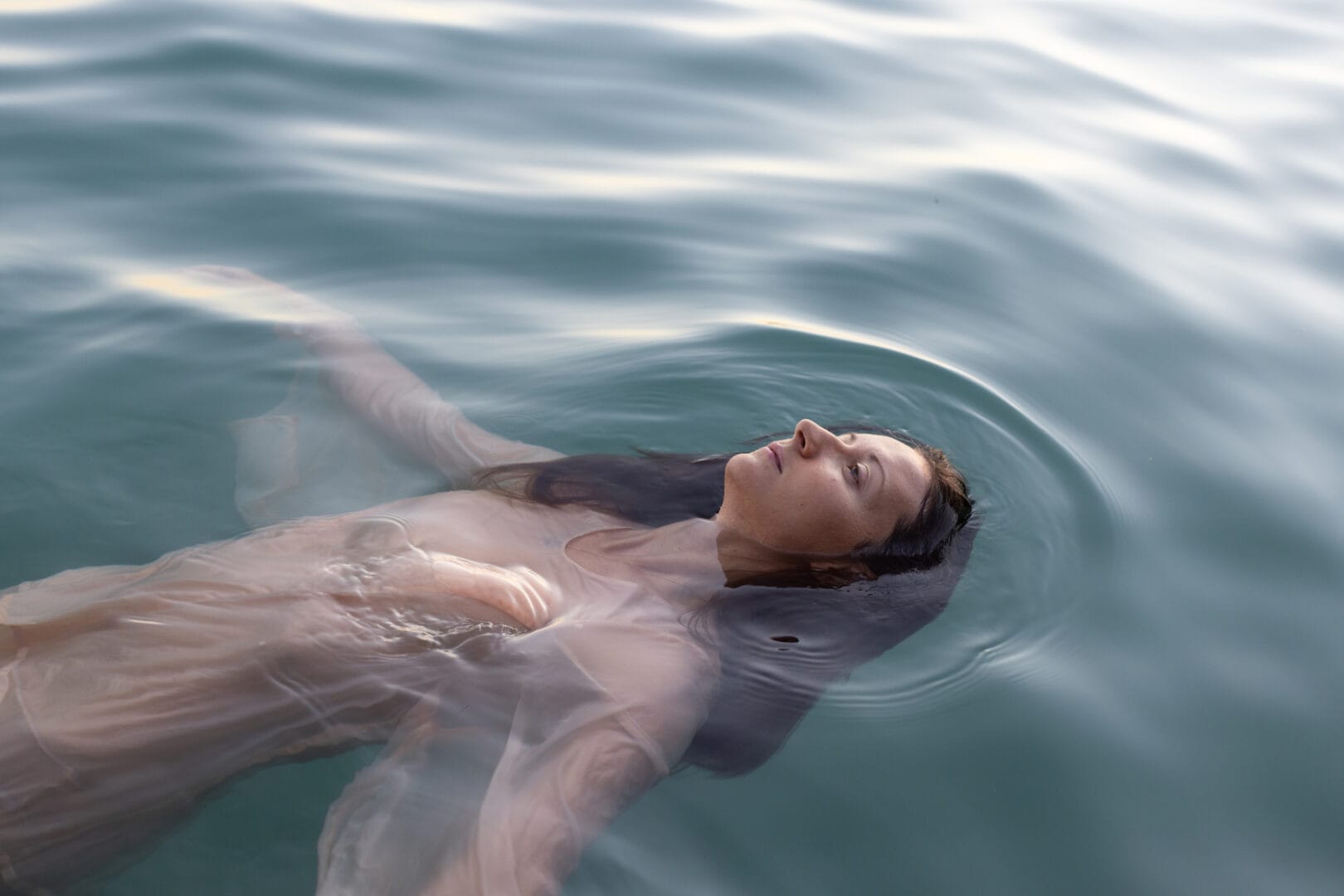 young calm sad woman bathing in the lake, depression or apathy, mental health